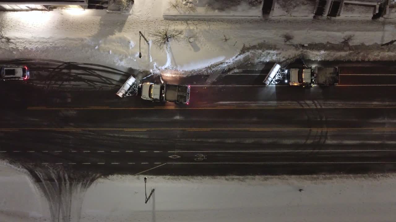 Snowplows working in tandem during the night, efficiently clearing snow from the streets of Mississauga, Ontario, amidst winter's chill