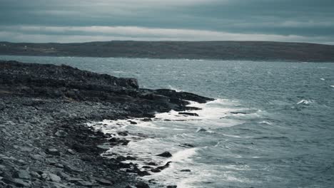 heavy waves roll on the dark rocky shore