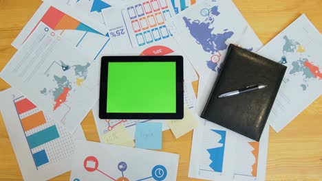 hombre usando una tableta con pantalla verde en el escritorio de la oficina, espacio de trabajo, búsqueda de información