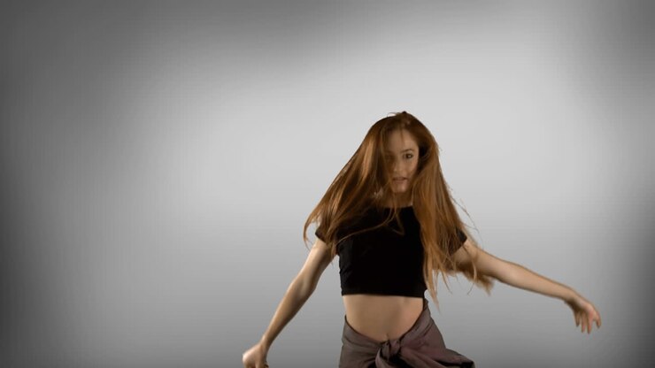 Woman dancing against grey background