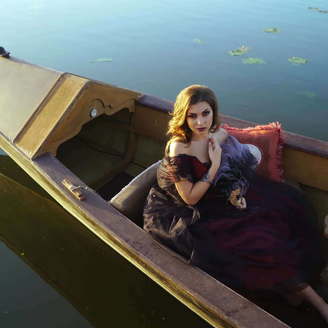Young woman in gondola in Venice. Woman with a carnival mask