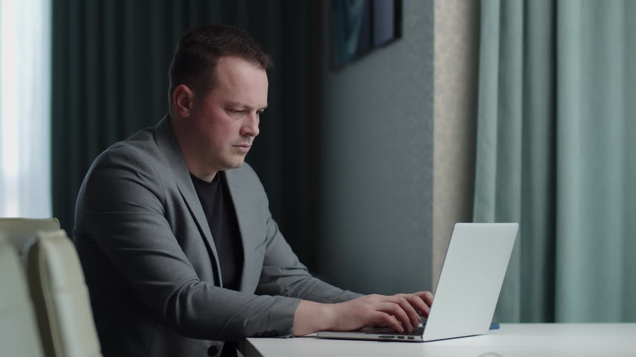 Man in business suit working online on laptop