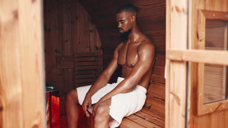 man relaxing in a wooden sauna