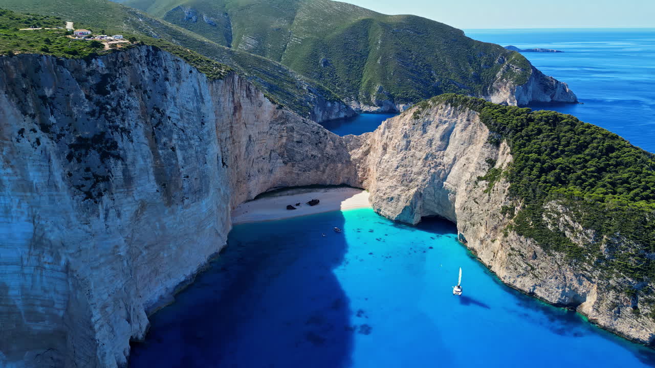 vuelo aéreo de drones playa de navagio grecia bahía azul acantilado verde viaje paisaje marítimo
