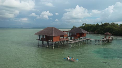 young couple enjoying vacation on a tropical island resort while kayaking together near a water bungalow in leebong indonesia