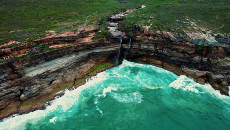 curracurrong falls, australia drone flys over couple, stream and waterfall