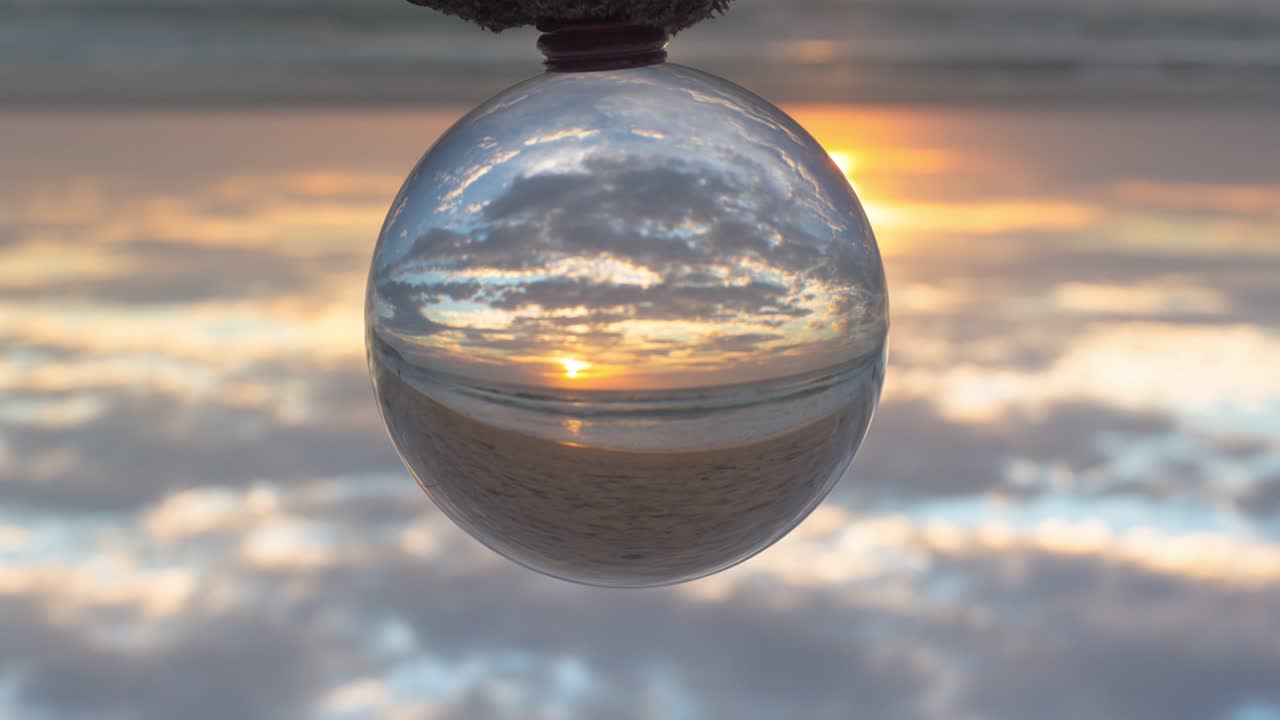 vista mágica del atardecer en la playa en una bola de cristal.