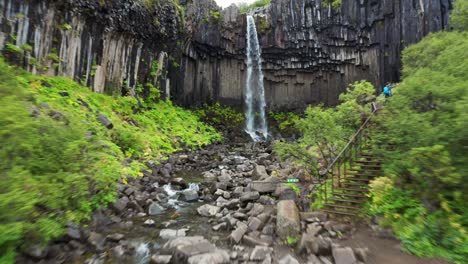 puente sobre el río con cascada svartifoss durante el verano en skaftafell en el parque nacional vatnajokull, islandia