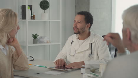 a young black doctor in a medical consultation with a ederly couple 2