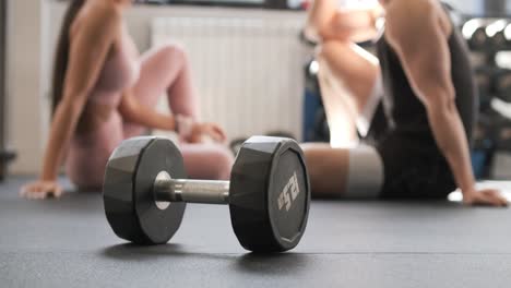couple relaxing after workout with dumbbell