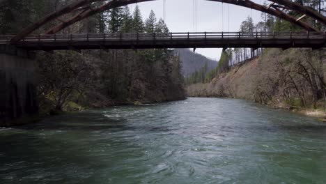 tioga bridge in umpqua national forest river, aerial backwards drone flight reveal