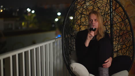 Woman-enjoying-wine-on-villa-balcony