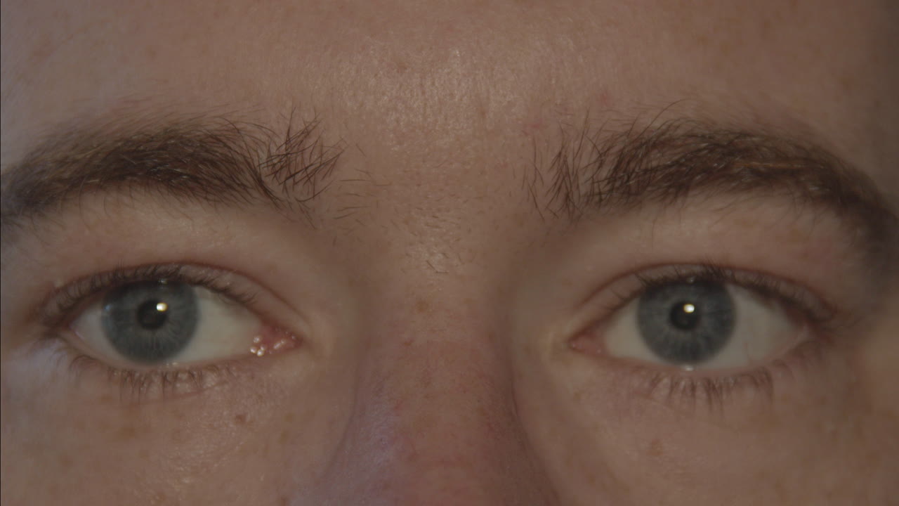 primer plano de un par de ojos azules masculinos mirando alrededor y parpadeando lentamente