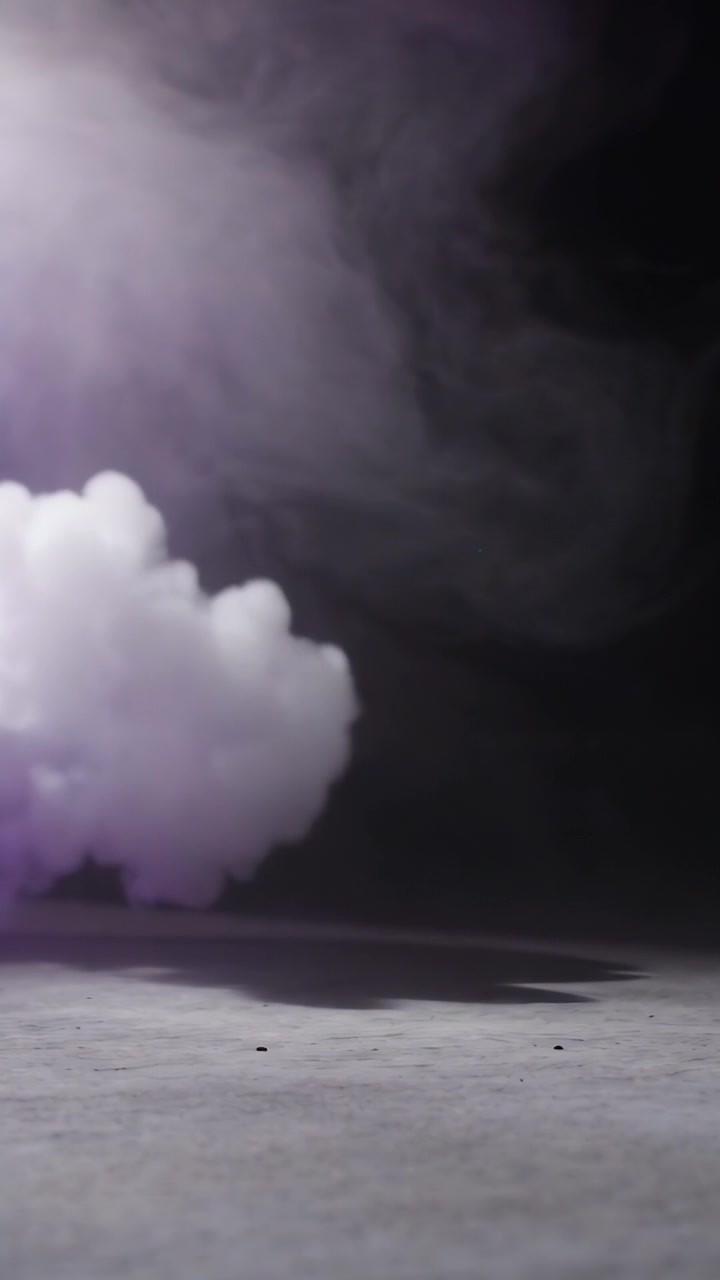 Video verticale: Soffio da sinistra che rilascia fumo, nebbia che si diffonde sul pavimento del palco per un'atmosfera viola.