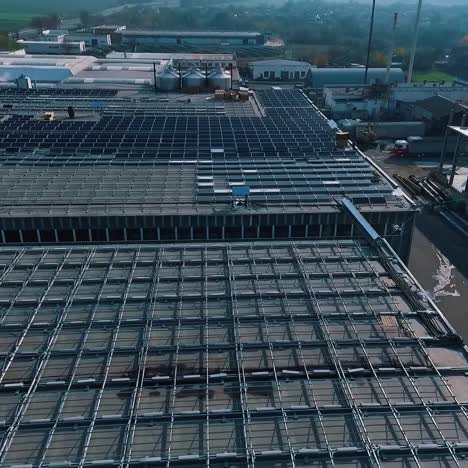 Construction of solar panels on industrial houses. Buildings with future solar panels on roof. Renewable energy from the sun