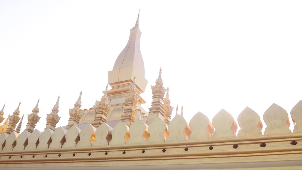 라오스의 비엔티안에 있는 파  루앙 황금 스투파 사원의 황금 첨탑을 통해 빛이 아져 나옵니다.