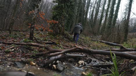 men hiking through a forest stream