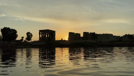 Hermosa-Oda-De-Amor-Templo-De-Philae-A-La-Luz-Del-Atardecer-El-Hermoso-Templo-De-Philae-Y-Los-Edificios-Grecorromanos-Se-Ven-Desde-El-Río-Nilo-Un-Templo-Dedicado-A-Isis,-Diosa-Del-Amor-Asuán-Egipcio