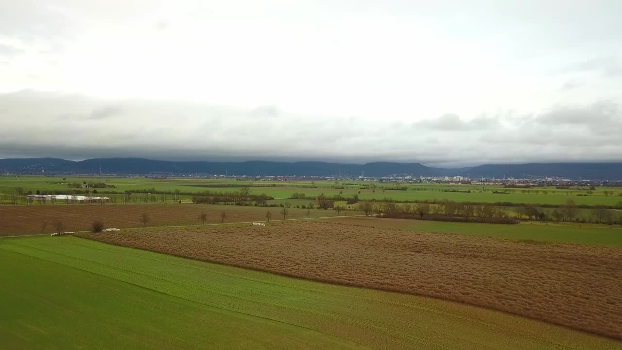 подъем над сельскохозяйственным полем с горами на заднем плане осенним днем, германия
