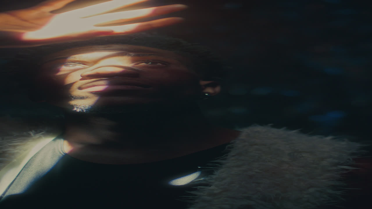 Young Man Covering Eyes with Hand as Looking upward at Strong Light