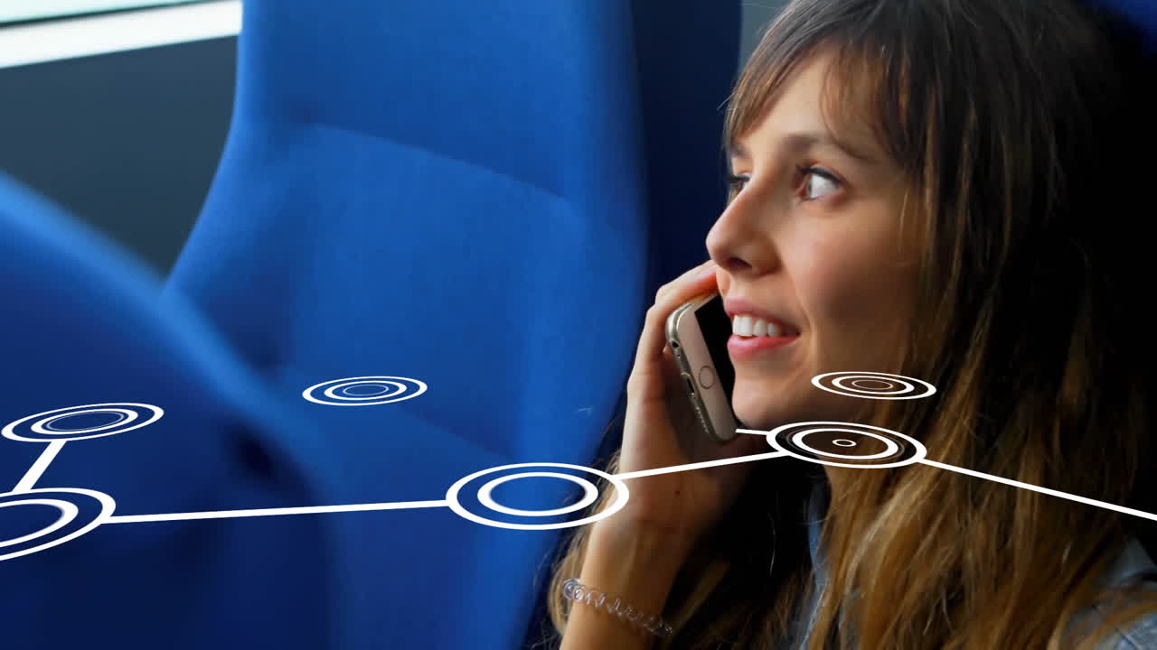 Woman holding smartphone to ear and smiling in train carriage, showing digital network technology