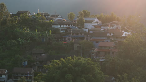 네팔의 람 (lamjung) 의 아침 해가 뜨는 모습을 드론으로 촬영하여 초록색으로 인 전통 건축물과 평화로운 환경, 평온한 아름다움 및 마을의 문화 유산을 보여줍니다.