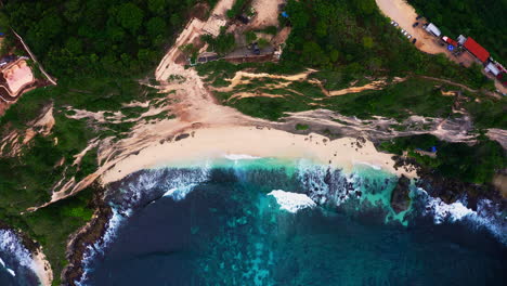 Sandy-Diamond-beach-washed-by-foamy-sea-waves-below-steep-cliff