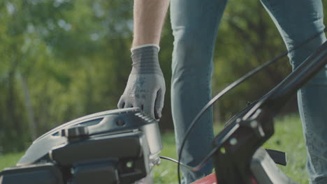 hombre comenzando una cortadora de césped