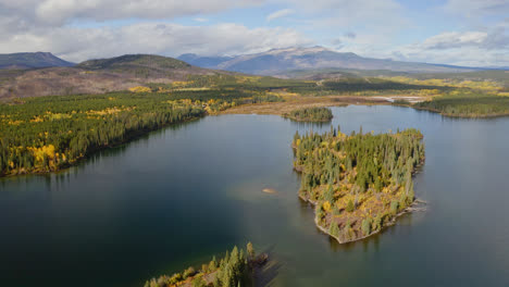 flyover above scenic british columbia lake surrounded by autumn foliage