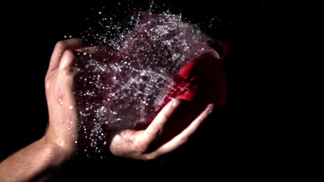 hand popping a water balloon