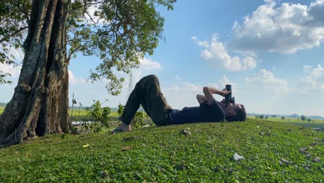 full shot of white caucasian man taking pictures of sky with dslr camera