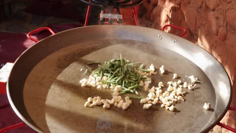 A-shot-of-a-paella-pan-outdoors-being-used-near-another-in-a-spanish-house-yard