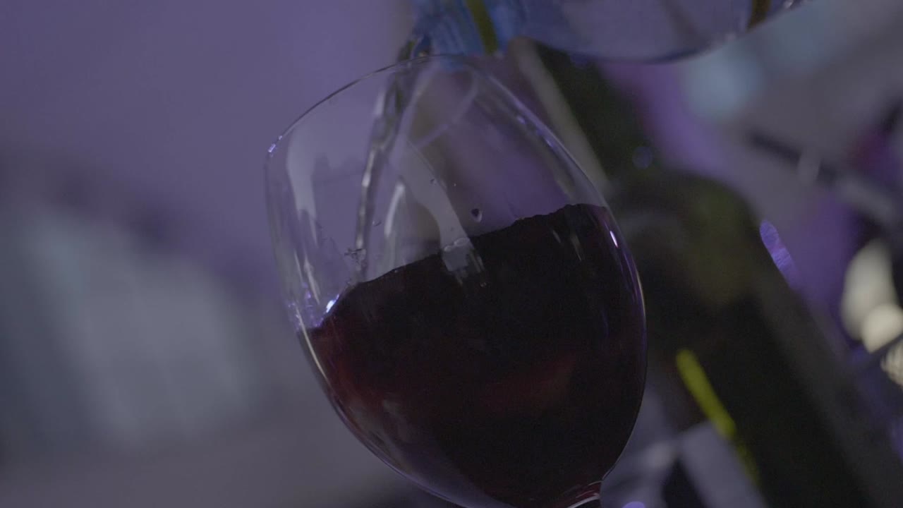 Pouring water into a glass of red wine