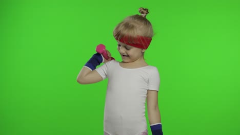 caucasian girl in sportswear making exercises with dumbbells. workout for kids. athletic child