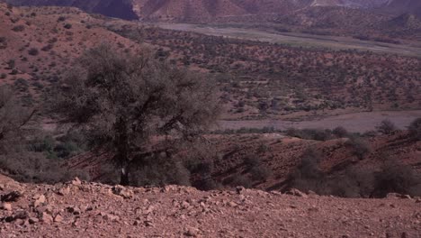 panoramic view of high voltage electric tower amidst morocco's mountains, pan from left to right