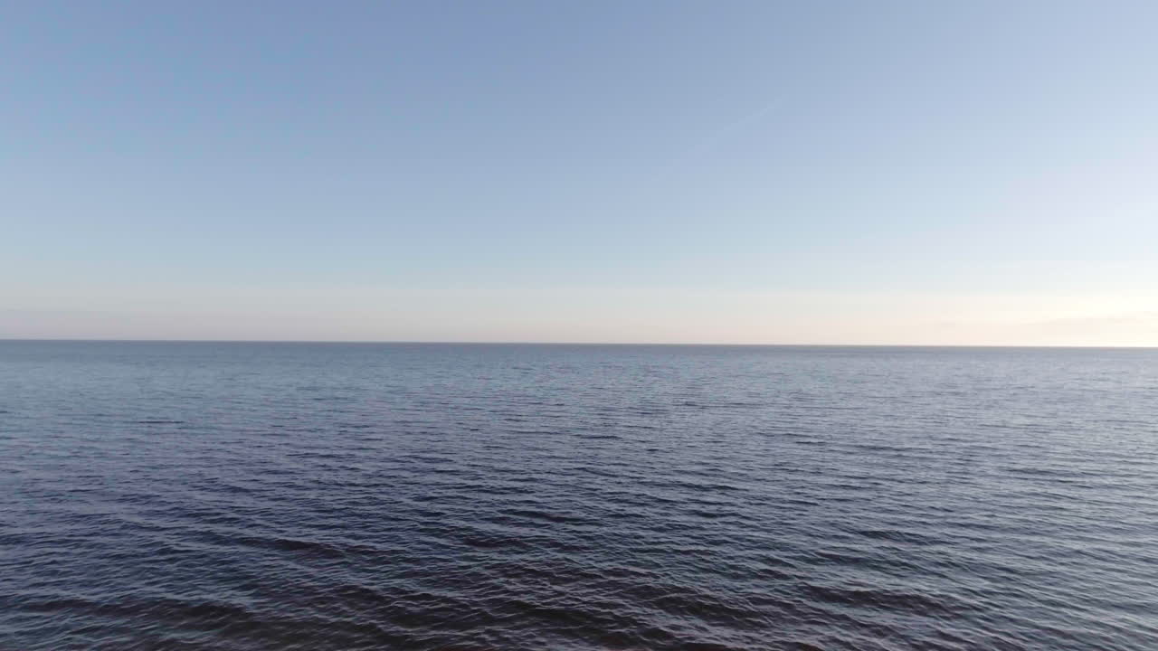 광범위한 공중 드론 영상은 해변에서 올라와 밝은 저녁에 잉글랜드 남쪽 해안에서 바다로 이동합니다.