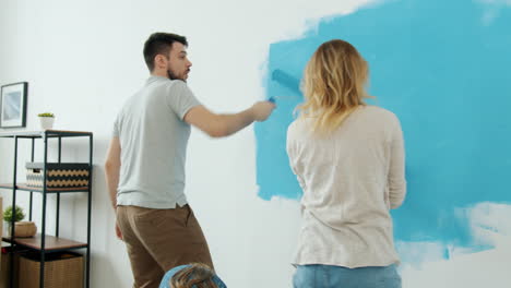 family painting a wall blue