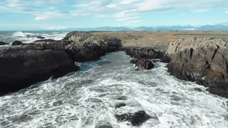 Olas-Rompiendo-Rocas-Negras-En-Imágenes-Aéreas-De-Islandia