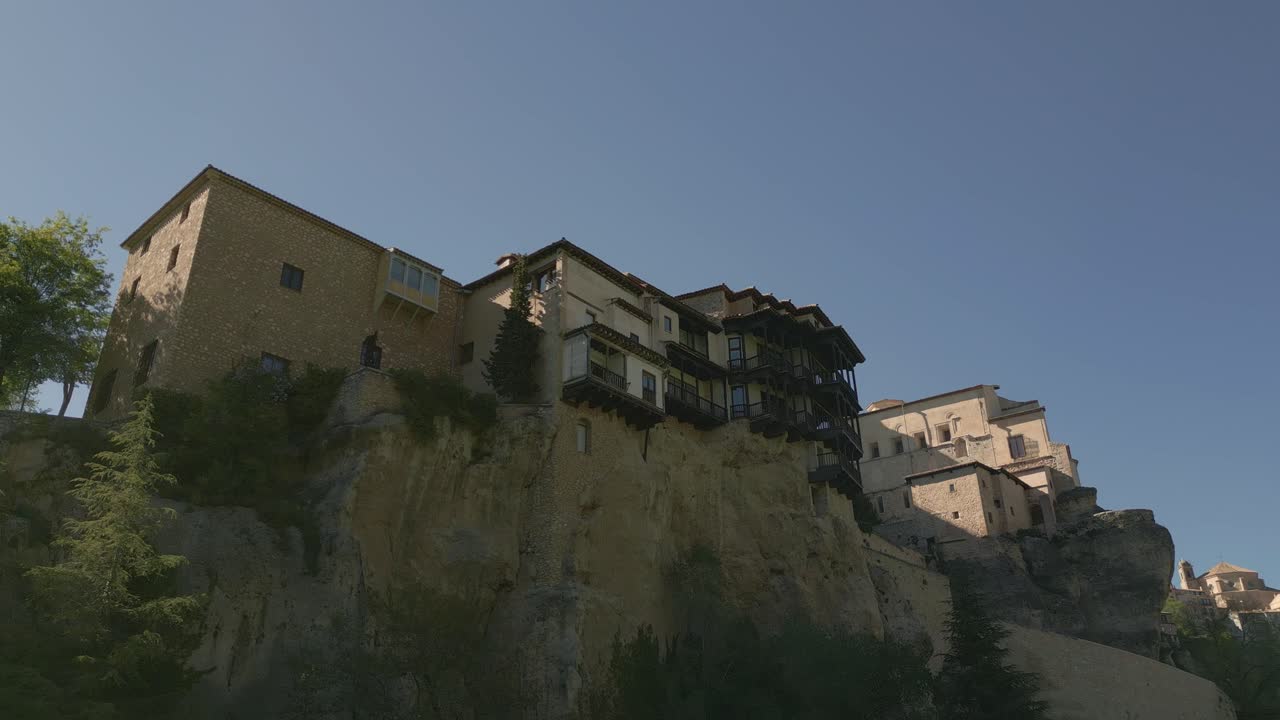 Houses hanging next to rocky precipice. Descend aerial view of medieval houses next to a cliff. Cuenca. Spain.