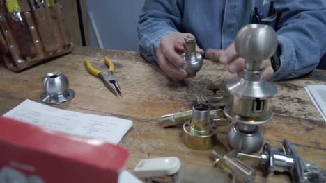 hombre latino experto en reparación de cerraduras servicio trabaja concentrado en la mesa en su taller