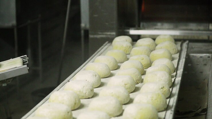 Fresh Unbaked Bread Dough In-Line Sprinkled By Wheat Flour Ready For Baking In The Big Oven