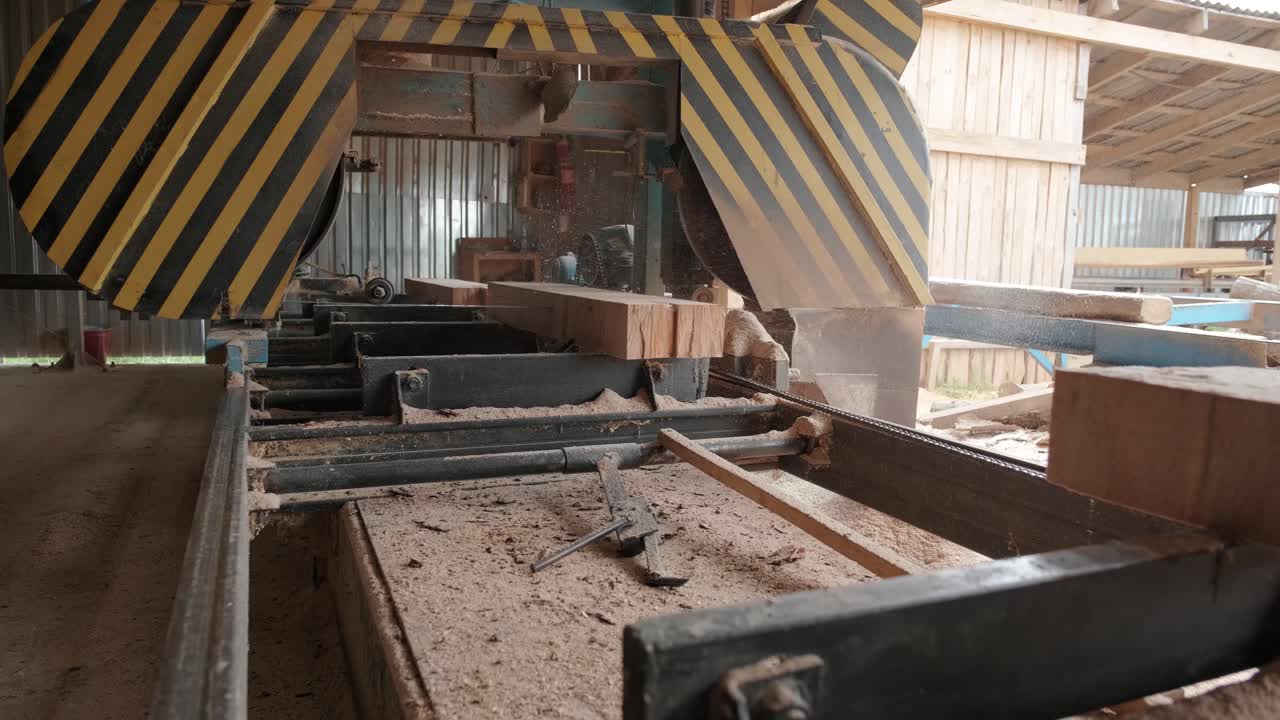 máquina de aserradura en la fábrica de producción de madera. procesamiento y corte de material de madera en el aserradero. proceso de fabricación en el molino de madera. máquina de aserrado circular automática