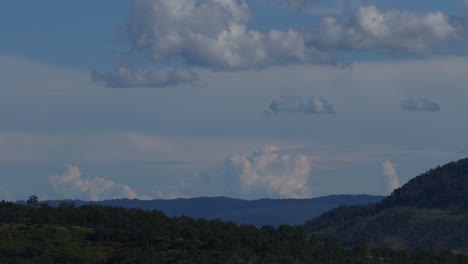 watch clouds gently move across a serene landscape of forested hills and open sky.