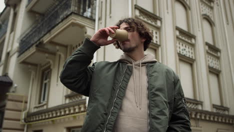 serious guy holding coffee outdoor