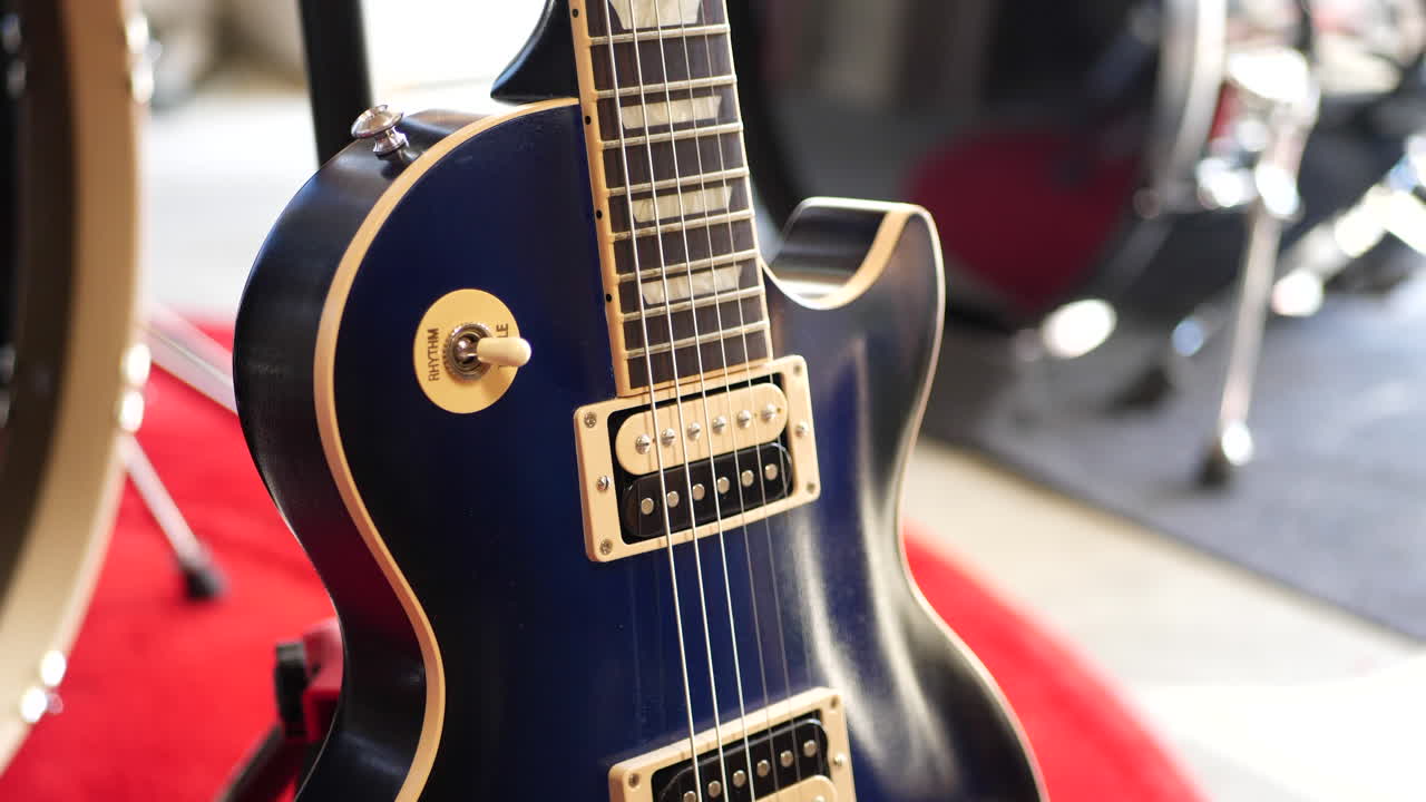 Rock and roll garaj grubu konseptinde bir konser sahnesinde duran vintage mavi bir elektro gitar