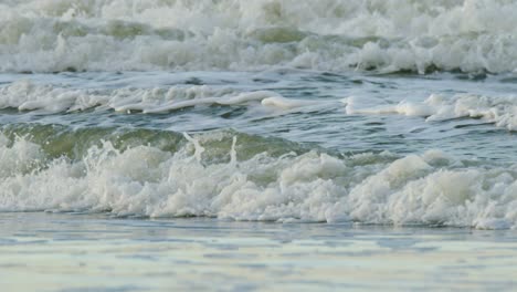 Tropical-sea-waves-rolling-and-crashing-near-sandy-beach-making-sounds-and-foam