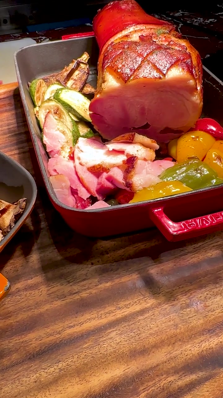 Een camera beweegt over geroosterde aardappelen, gegrilde courgette, aubergine en paprika op een buffet.