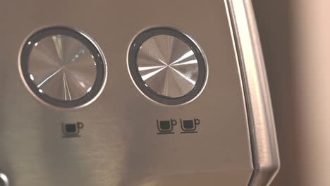 close-up of an expresso machine where the focus goes to the number of cups are selected