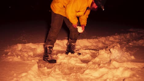 retrato recortado de un hombre pescando en un agujero de hielo por la noche