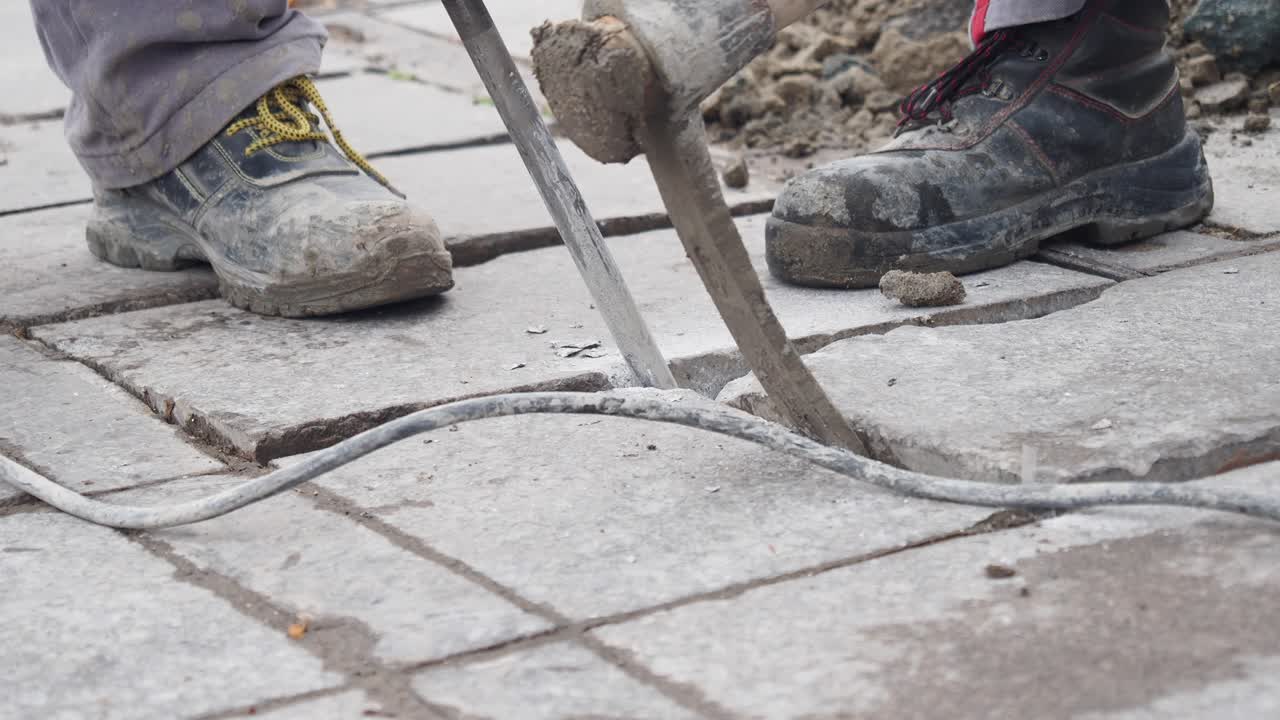 콘크리트를 깨뜨리기 위해 잭햄머를 사용하는 건설 노동자